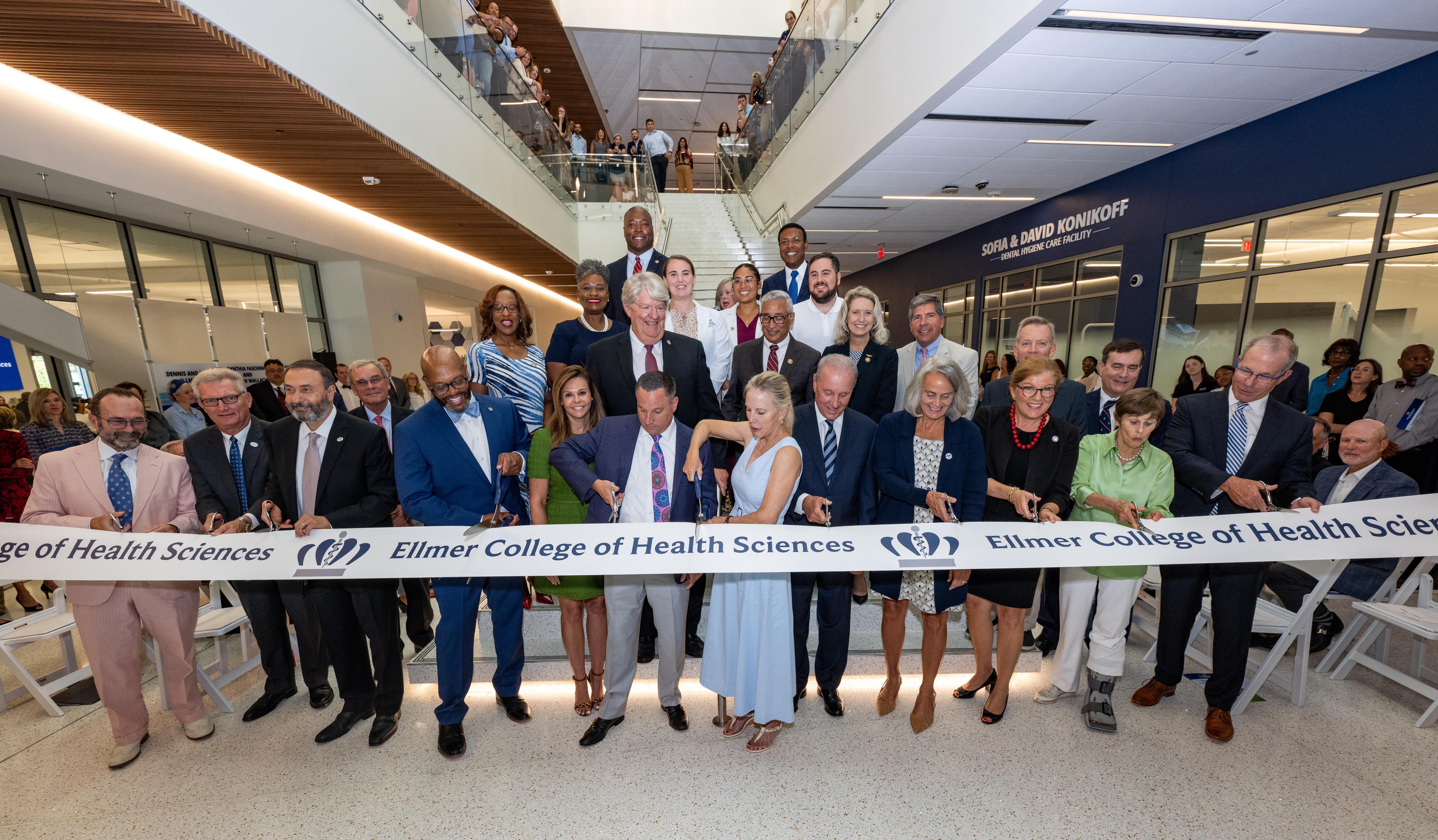 group of people cutting a grand opening ribbon