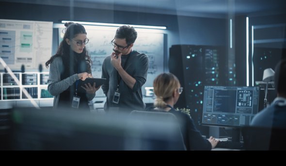 People in a computer lab looking at a tablet