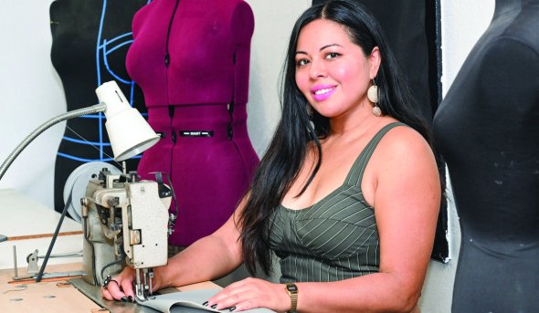 a woman sits at a sewing machine 