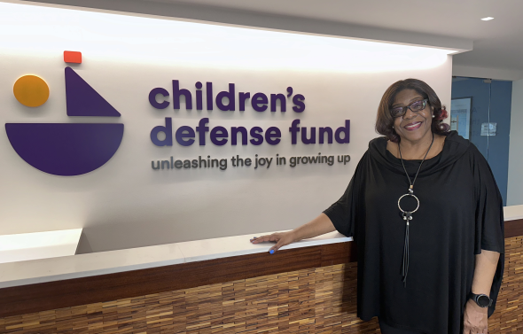 a woman stands in front of a sign 