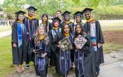 Graduates pose on campus