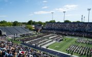 Thousands of people sit before a stage in a stadium.